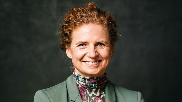 Ein Portraitfoto von Kathrin Siemer. Ein Frau, schätzungsweise 50 Jahre alt mit roten, lockigen und hochsteckten Haaren. Sie lächelt, trägt einen grünen Blazer und hat ihre Arme verschrenkt. Ein Portraitfoto von Kathrin Siemer. Ein Frau, schätzungsweise 50 Jahre alt mit roten, lockigen und hochsteckten Haaren. Sie lächelt, trägt einen grünen Blazer und hat ihre Arme verschrenkt.